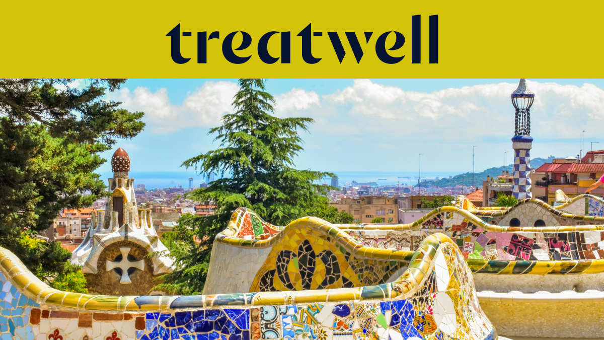 Een schilderachtig uitzicht op Barcelona vanaf Park Güell, met de iconische kleurrijke mozaekbanken van Antoni Gaudí en sprookjesachtige torens op de voorgrond, met de stad en de zee in de verte. Bovenaan een gele banner met het "treatwell"-logo.